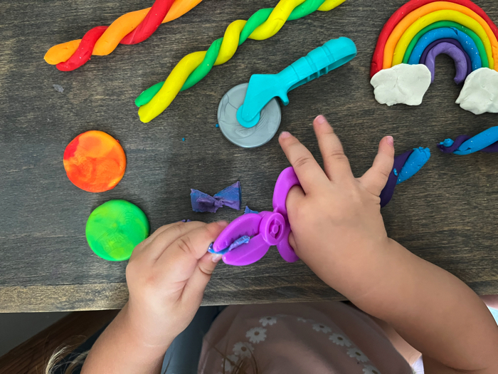 Using scissors in your rainbow playdough cutting station.