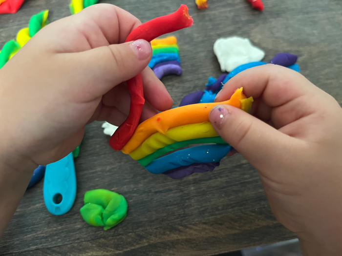 Pulling apart playdough in your rainbow playdough cutting station.