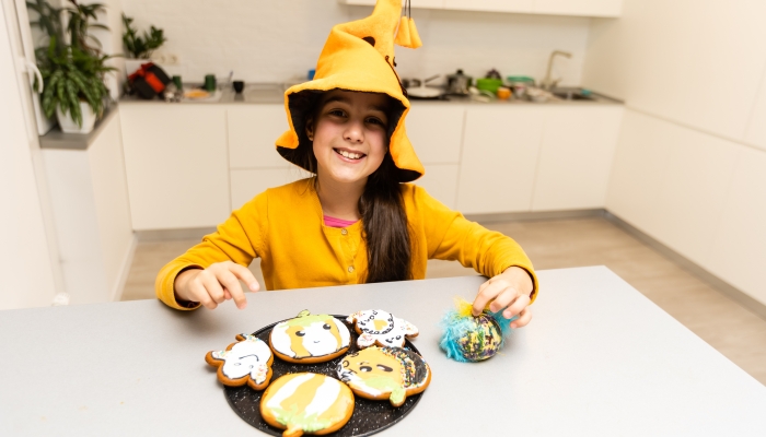 Cute little witch with cookies pumpkins.