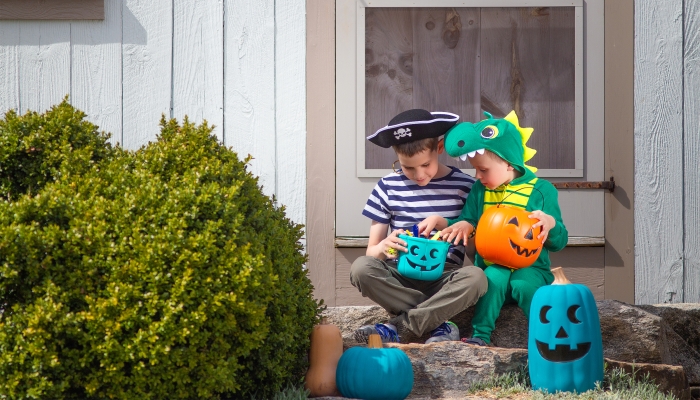 Halloween kids sitting on porch after trick or treating.