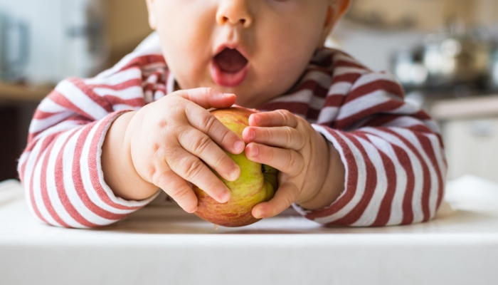 Healthy cute caucasian baby boy have apple.