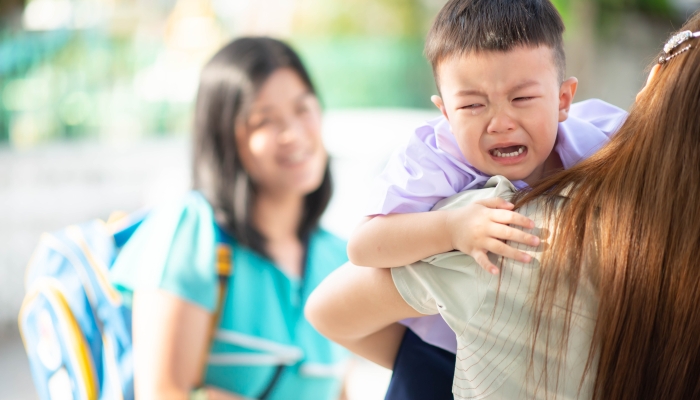 Little toddler boy cry, first day at school kindergarten with mother.