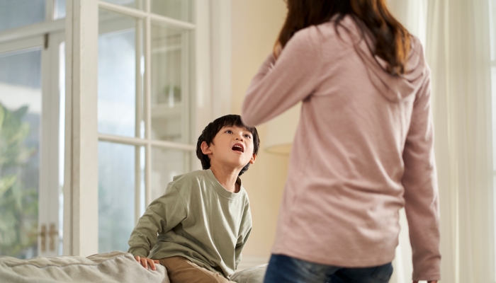 Young asian mother and naughty son getting confrontational at home.