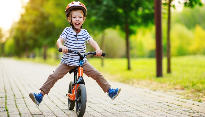 happy child boy rides a racetrack in Park in the summer.