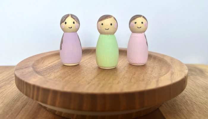 Three finished painted peg dolls.