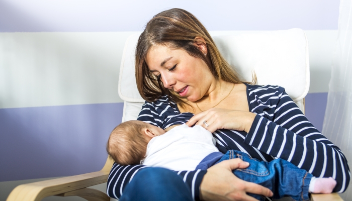 A mother Breast feeding his baby at home.