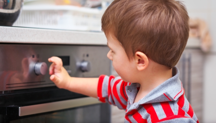 Child playing with electric oven.