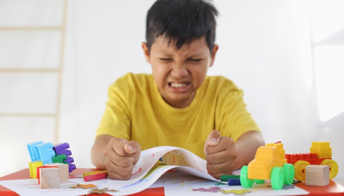 Emotional Tantrum and Angry boy while drawing on paper.