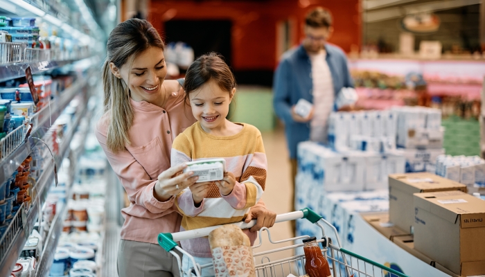 Happy mother and daughter reading nutrition label.