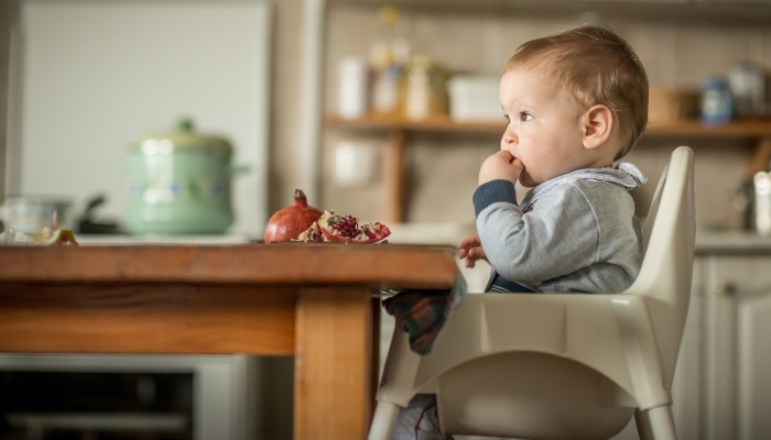 Portrait Of Happy Young Baby Boy In High Chair.
