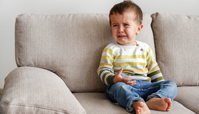 Upset toddler throwing a tantrum at home.