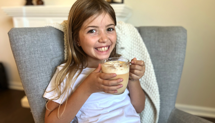 Young girl drinking a pumpkin spice latte.
