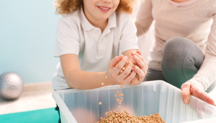 Boy playing with chickpeas during his sensory integration therapy.