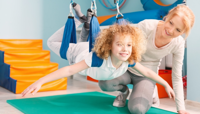 Child and his therapist exercising during sensory integration therapy