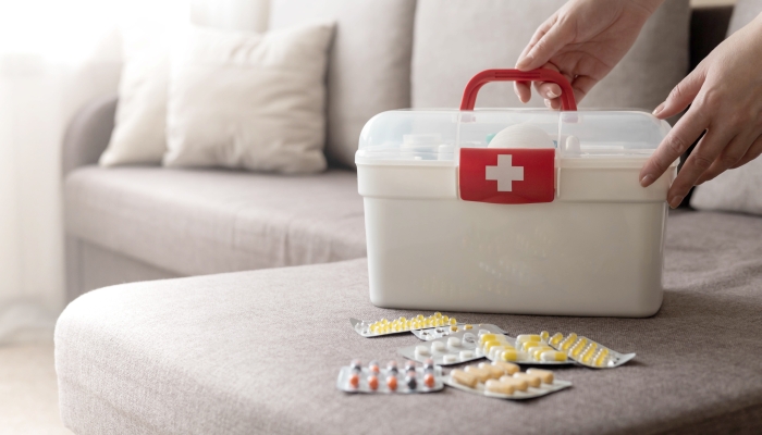 Closeup female hand neatly placing medicament at domestic first aid kit..