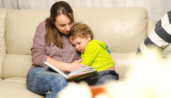 Mother and child reading book at home.