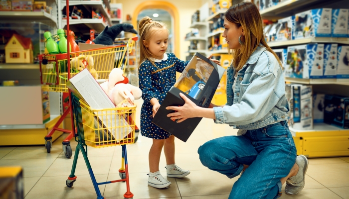 Mother and pretty little baby buying toys in store.