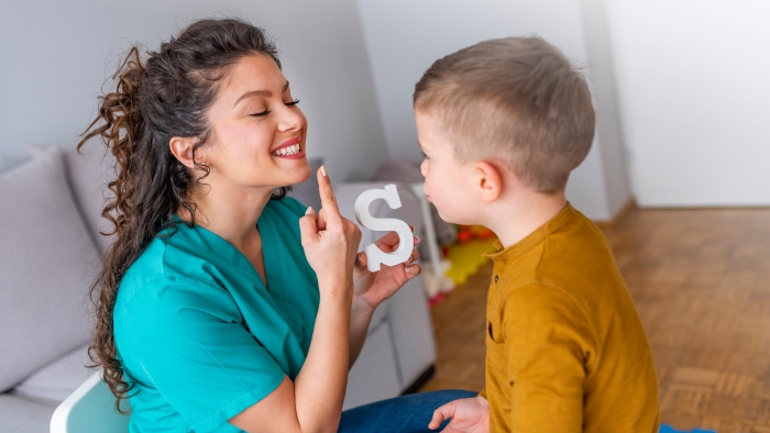 Speech therapist and little patient training articulation.