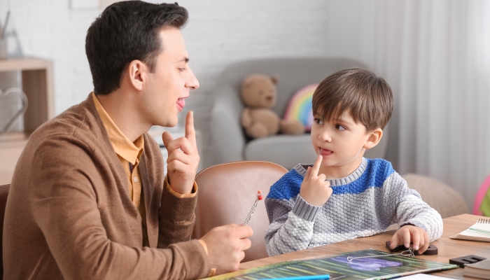 Speech therapist working with little boy in office.