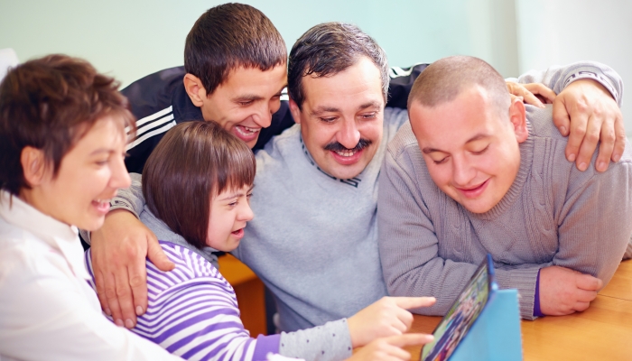 Group of happy people with disability having fun with tablet.