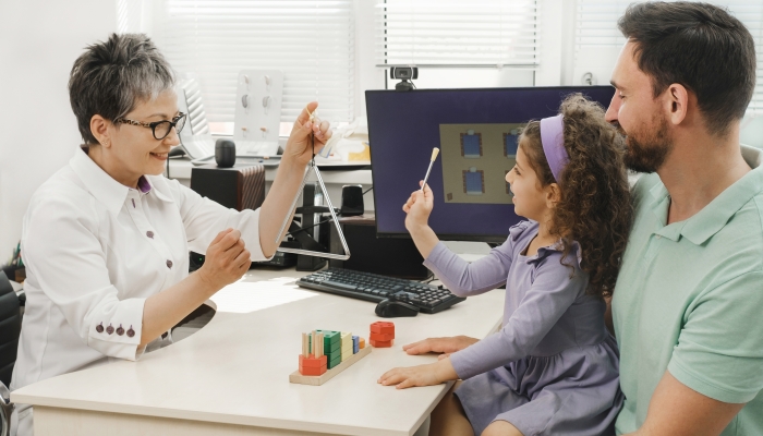 Speech therapist working with child who has hearing problems.