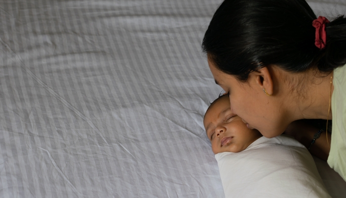 A mother kissing her new born baby boy, girl.