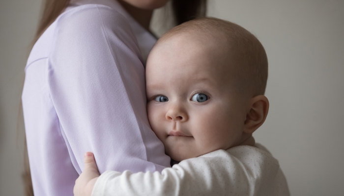 Close up head shot loving young woman cuddling sweet adorable baby.