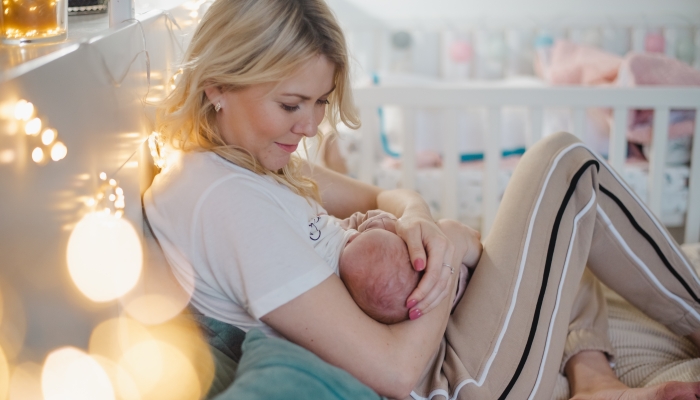 Happy mom breastfeed her newborn baby.