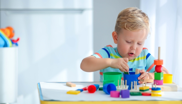 Little boy 2 years old is played with a colors toys.