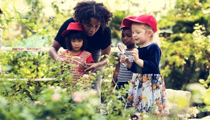 Teacher and kids learning ecology gardening.