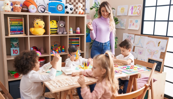 Woman and group of kids having vocabulary lesson at kindergarten.