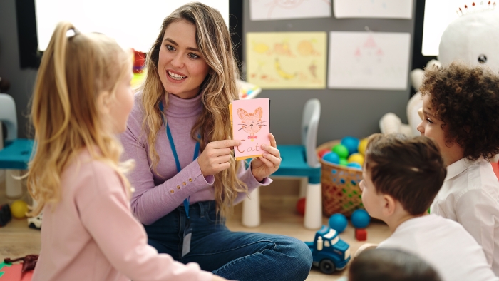 Woman and group of kids having vocabulary lesson with word cards at kindergarten.