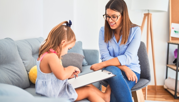 Young therapist woman speaking and treating child.