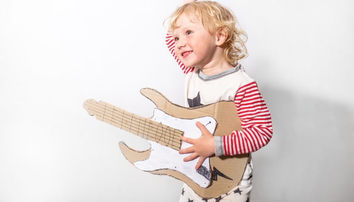 Little funny girl with DIY guitar.