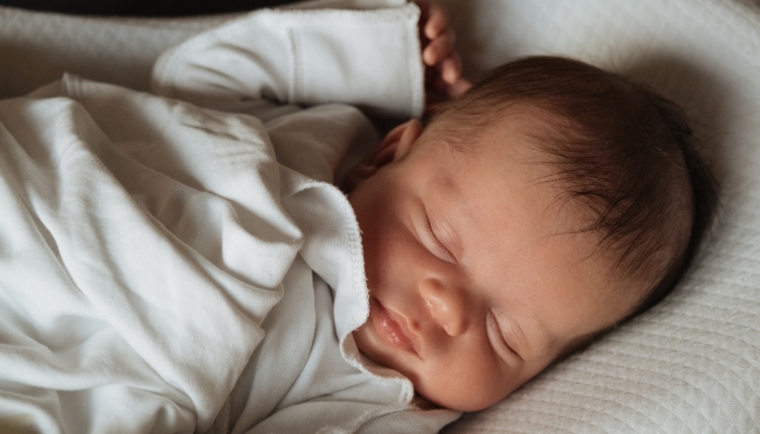 Beautiful caucasian newborn baby Child sleeping in bed.
