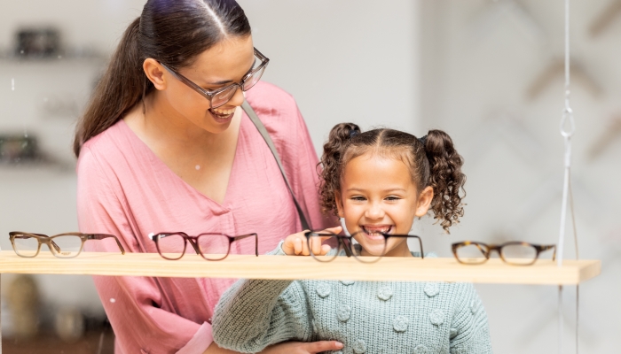 Decision, glasses and girl with her mother at the optometrist for vision and check on eyes together.