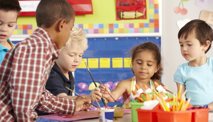 Group Of Elementary Age Schoolchildren In Art Class.