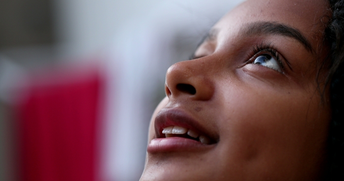 Hispanic black girl child opening eyes to sky smiling face close-up.