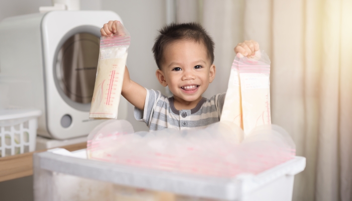 Little asian boy shows his frozen breast milk.
