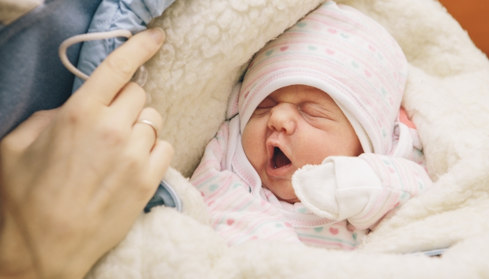 Little infant newborn child in maternity hospital on his mothers arms.