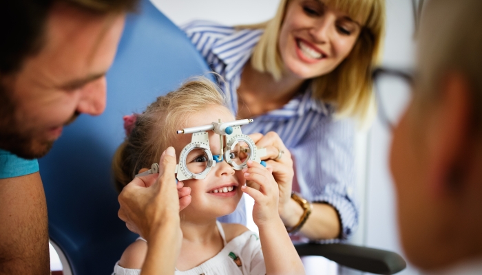 Ophthalmologist, optometrist checking child vision looking for problems and caring for eye.