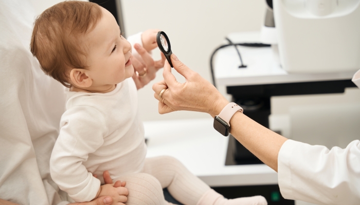 Pediatric oculist checking child vision during consultation.