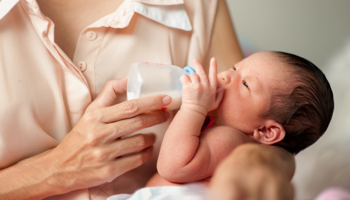 Portrait one day old of little cute adorable Asian infant baby drinking Breastfeed through baby bottle.