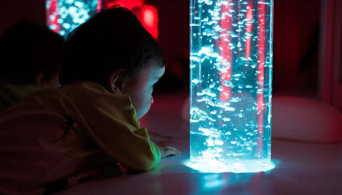 Young kid exploring a multi sensory space - snoezelen concept.