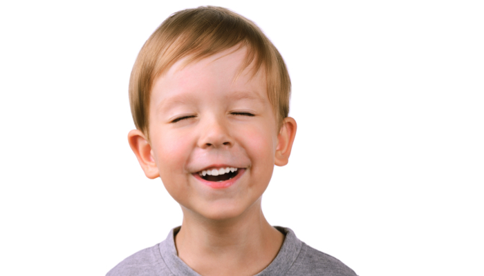 A young boy with his eyes closed.