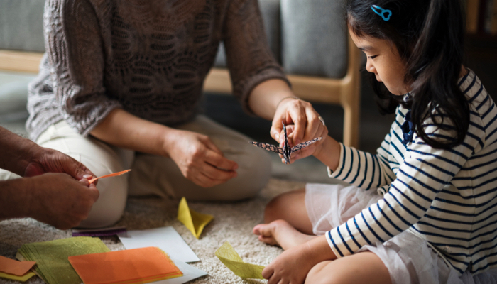 Family working on origami together.