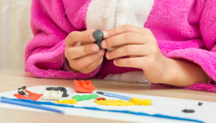 A child holding a blank crafts from plasticine.