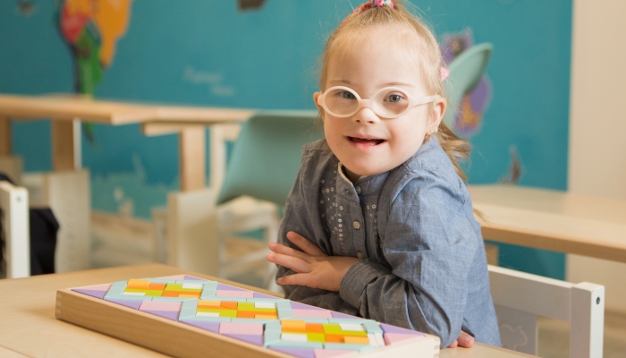 Beautiful girl with down syndrome engaged in class.
