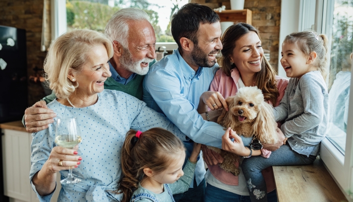 Cheerful multi-generation family with a dog having fun while spending time together at home.