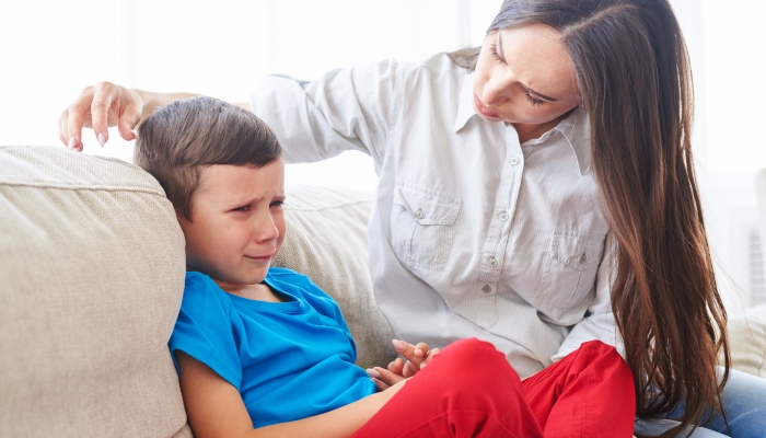 Close-up shot of young caregiver trying to comfort and calm down a crying child.